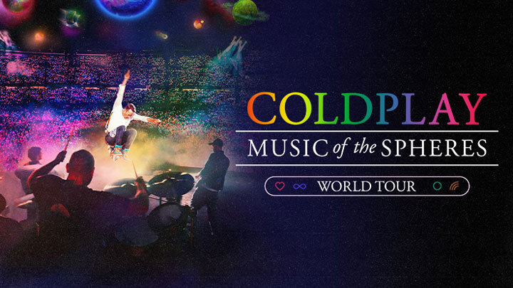 Chris Martin on stage performing next to the name Coldplay