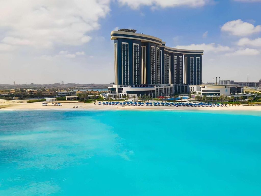 Modern high rise hotel next to incredibly turquoise blue water