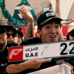 Enthusiastic young fan holding a commemorative UAE F1 sign with the number 22 at the Abu Dhabi Grand Prix
