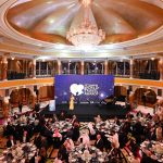 Opulent ballroom setting for the World Travel Awards gala dinner, featuring a large crystal chandelier and stage