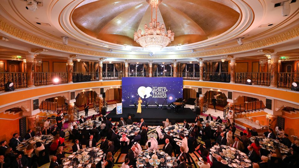 Opulent ballroom setting for the World Travel Awards gala dinner, featuring a large crystal chandelier and stage